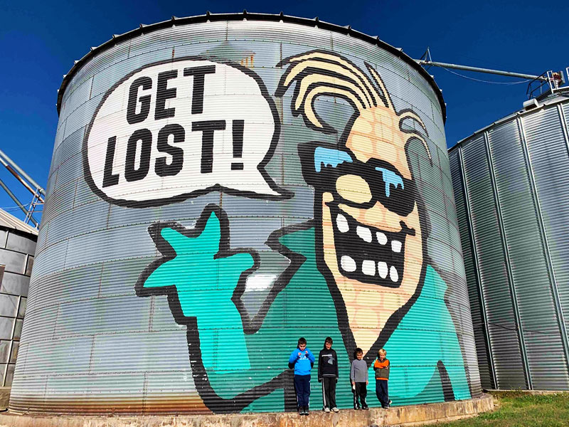 "GET LOST" - Our Cornelius corn mascot waving on the side of the silo